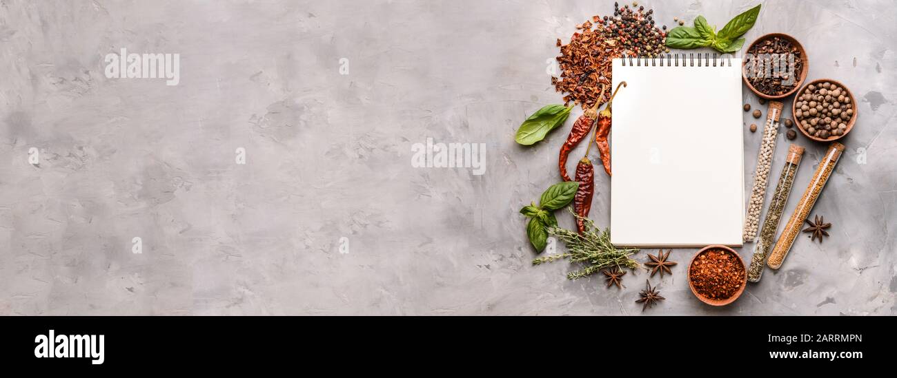 Empty notebook and different spices on grunge background with space for text Stock Photo