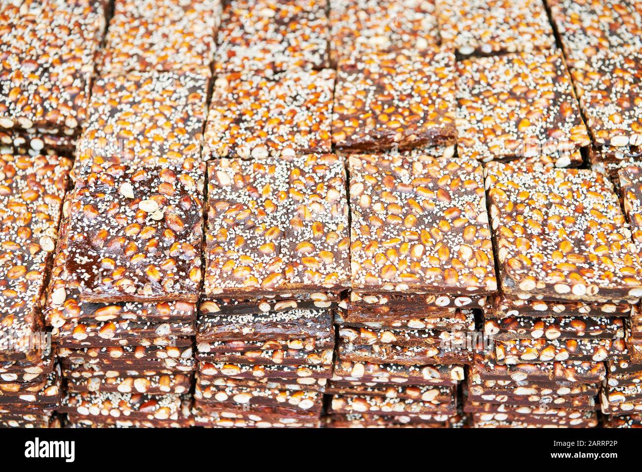 Peanut brittle bars covered with sesame seeds laying for sale on a table at a market in the Philippines Stock Photo