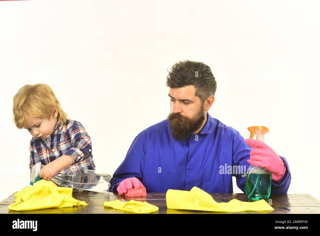 Guy with beard and mustache in rubber gloves at table. Kid with father