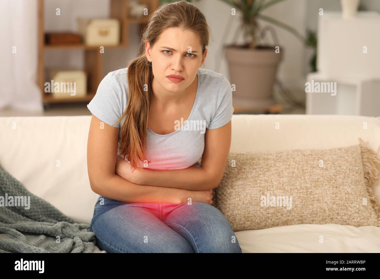 Young woman suffering from menstrual cramps at home Stock Photo - Alamy, image size:1300x956