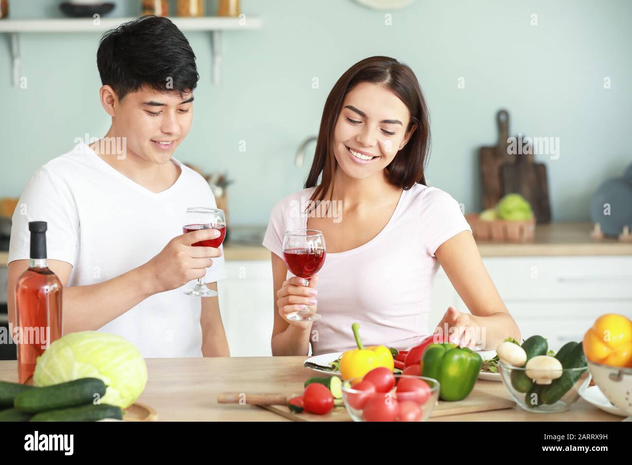 Happy couple drinking wine while cooking in kitchen Stock Photo Alamy