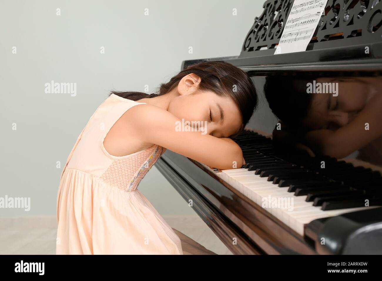 Little girl sleeping at grand piano Stock Photo - Alamy