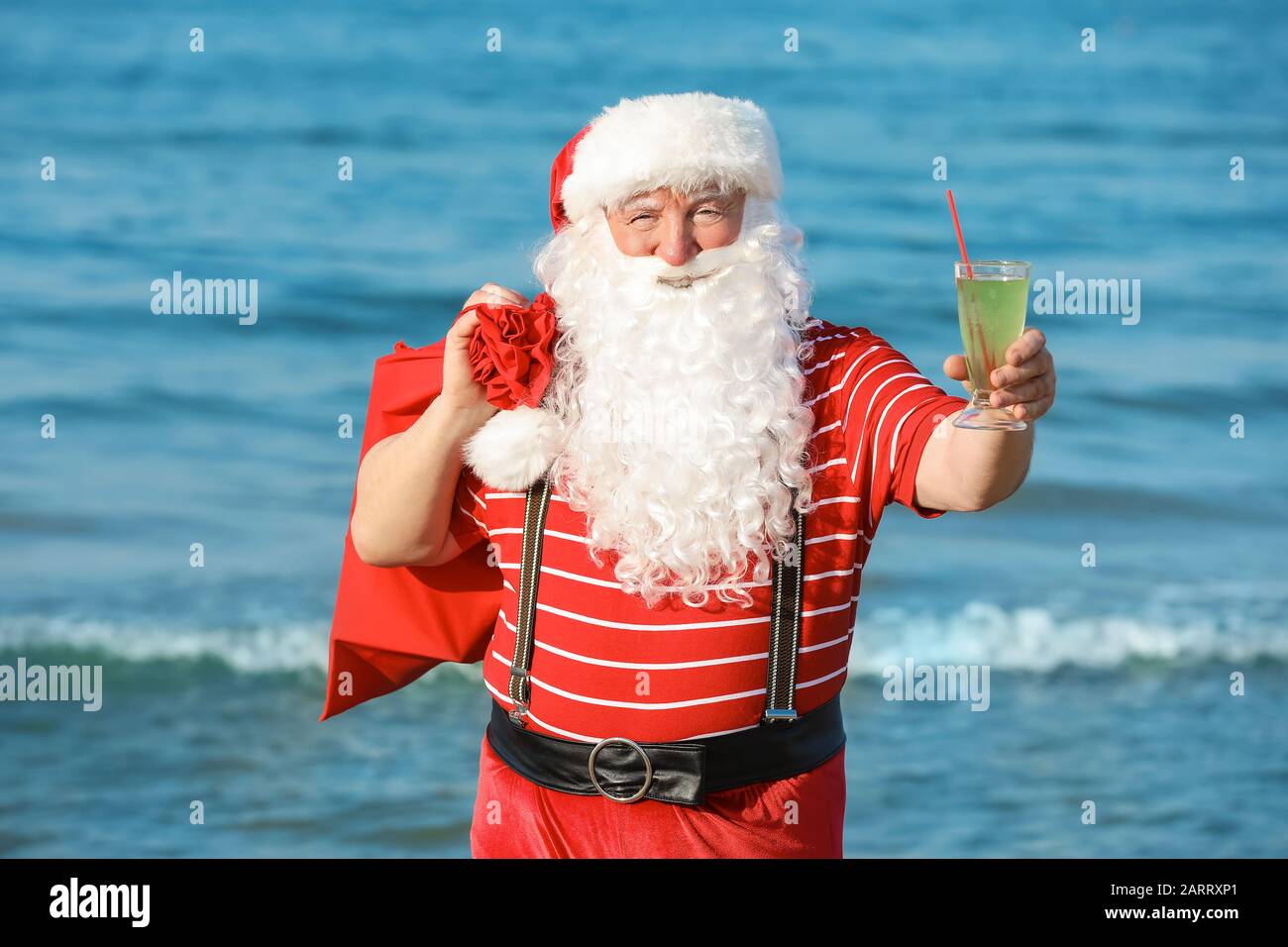 Santa Claus with gifts and cocktail at sea resort Stock Photo - Alamy