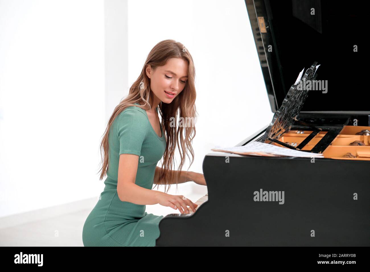 Young woman playing grand piano at the concert Stock Photo - Alamy