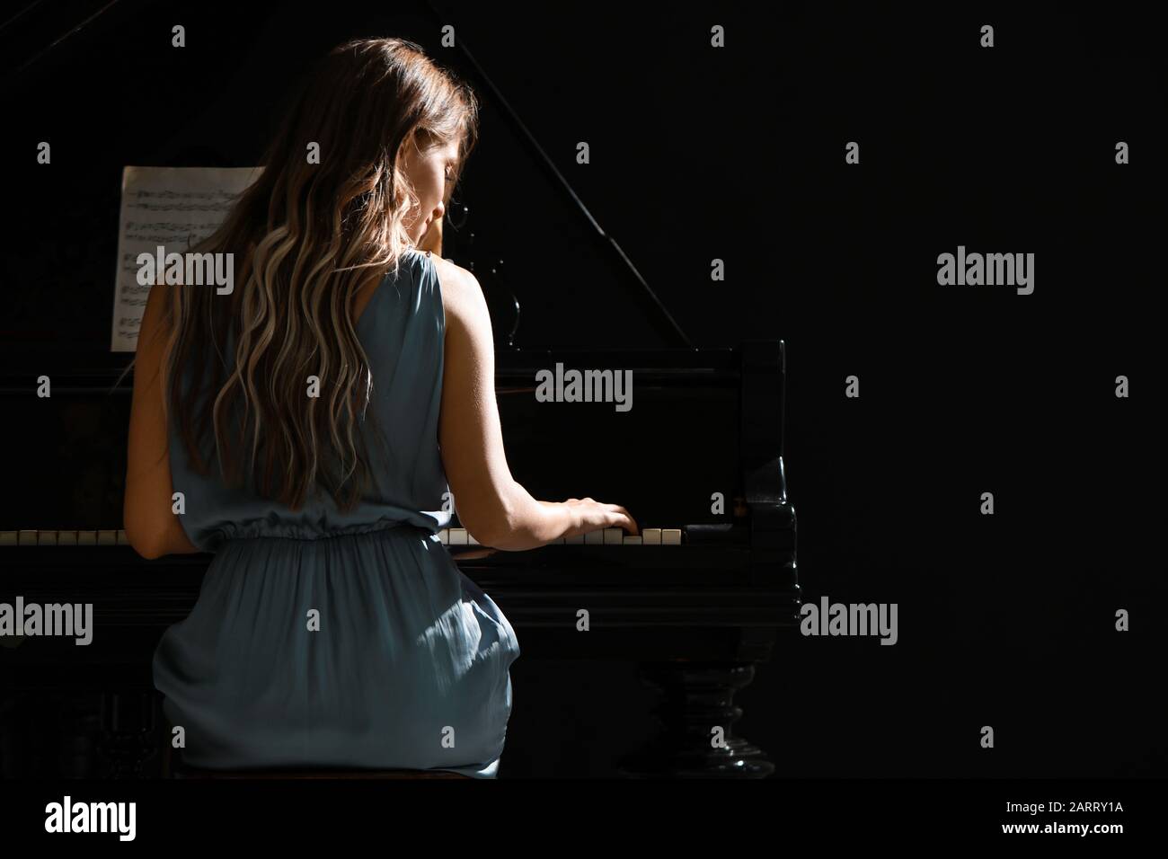 Young woman playing grand piano at the concert Stock Photo - Alamy