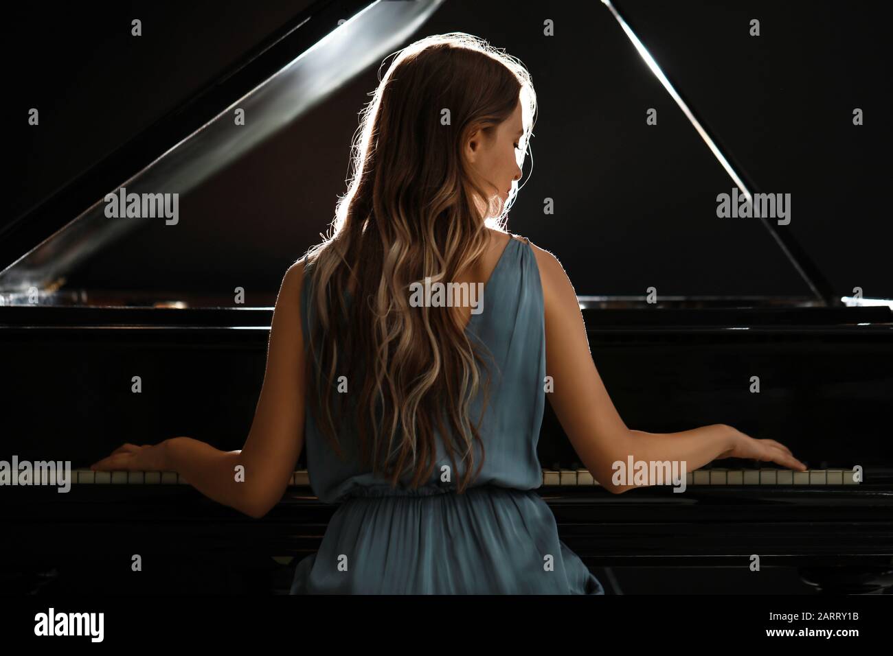 Young woman playing grand piano at the concert Stock Photo - Alamy