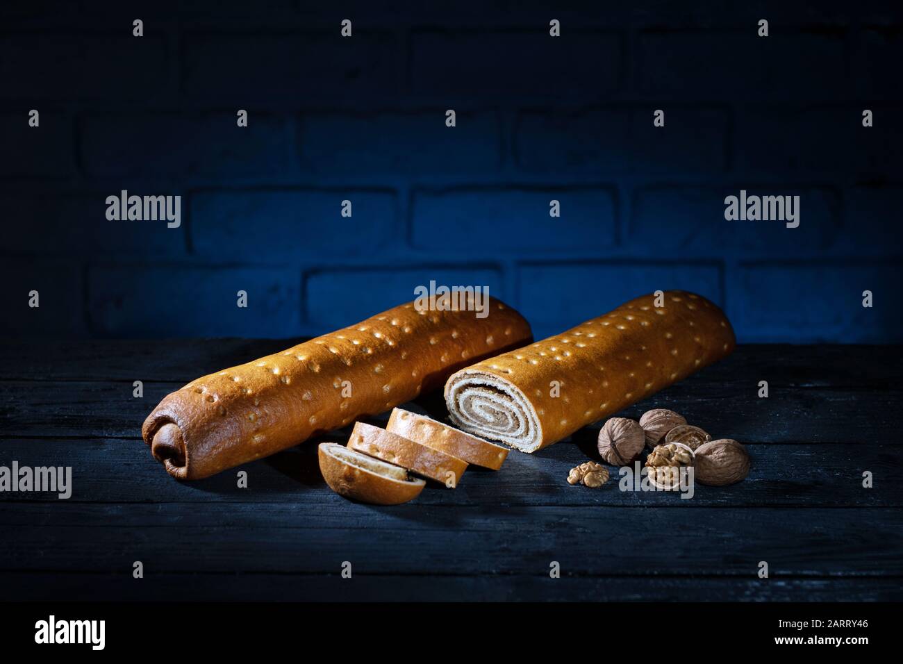 German sweet bread with walnut on burnt wooden table with blue brick background Stock Photo