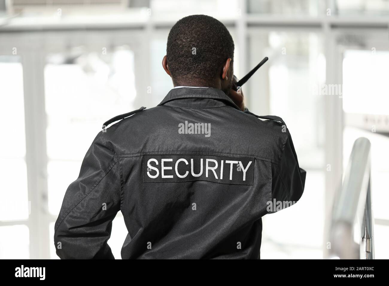 African-American security guard in building, back view Stock Photo - Alamy