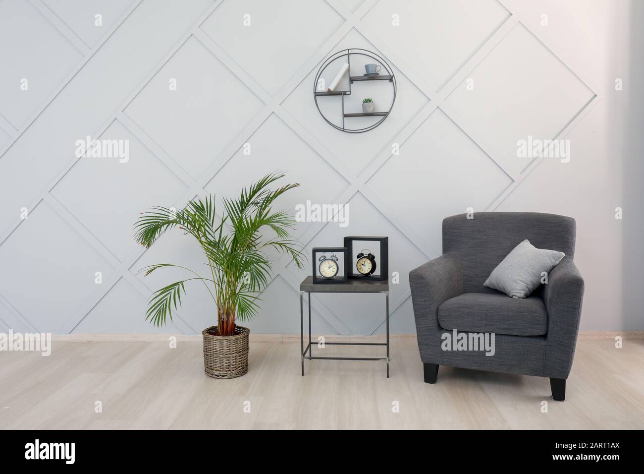 Stylish armchair with table and palm in interior of room Stock Photo ...