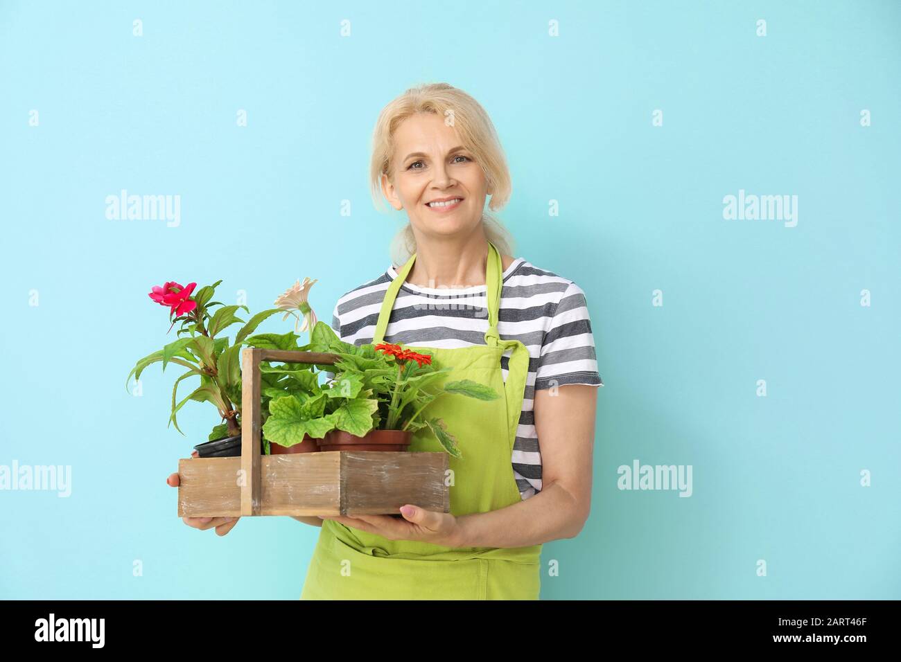 Portrait of female gardener on color background Stock Photo - Alamy