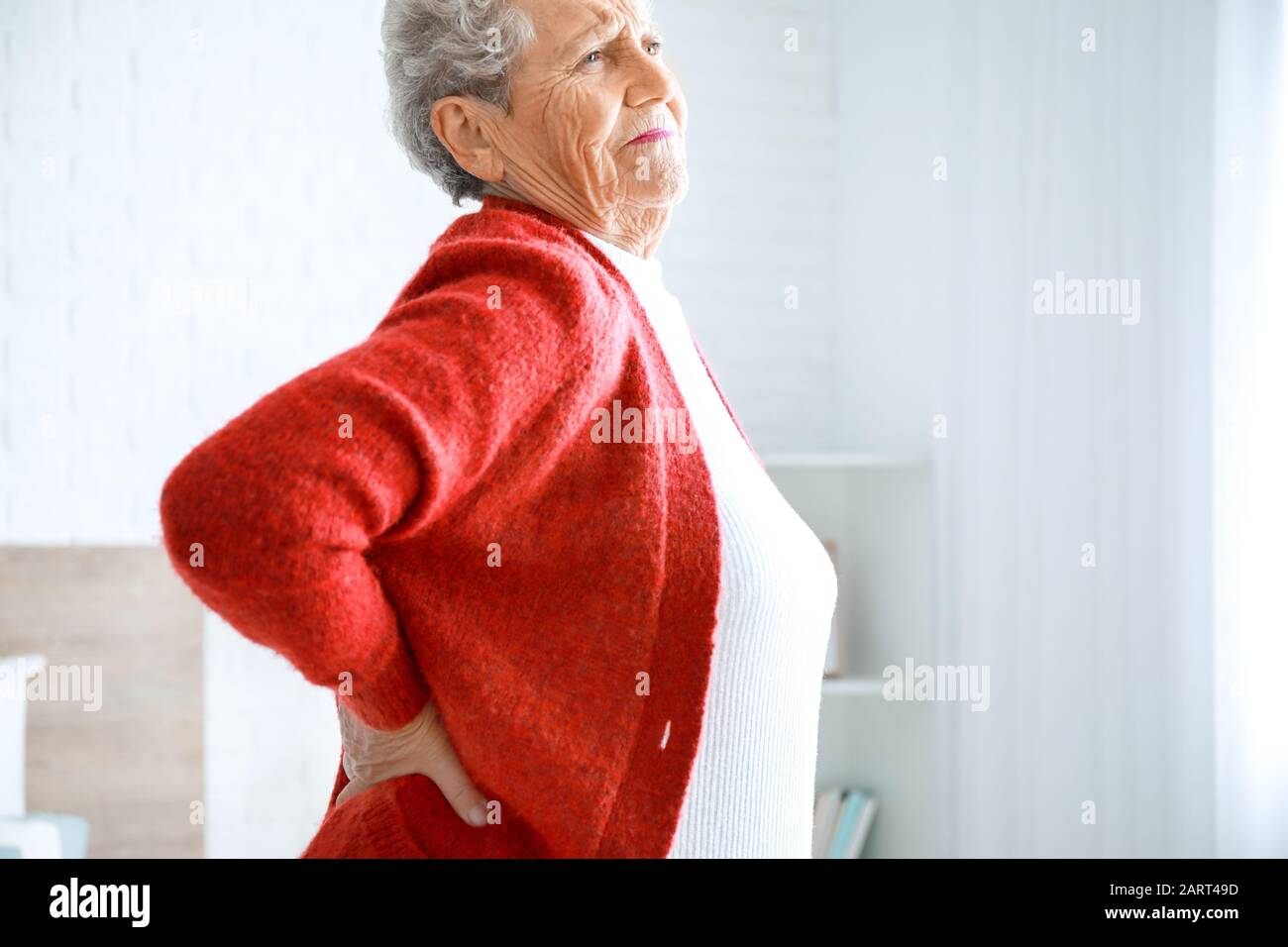 Senior woman suffering from pain in back at home Stock Photo - Alamy
