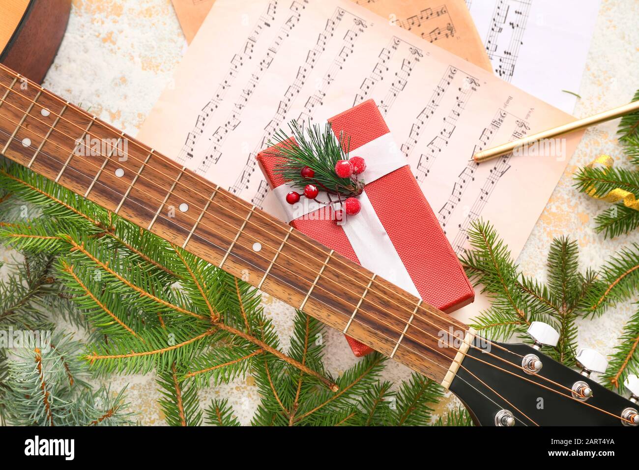 Guitar, note sheets, gift and Christmas decor on table Stock Photo
