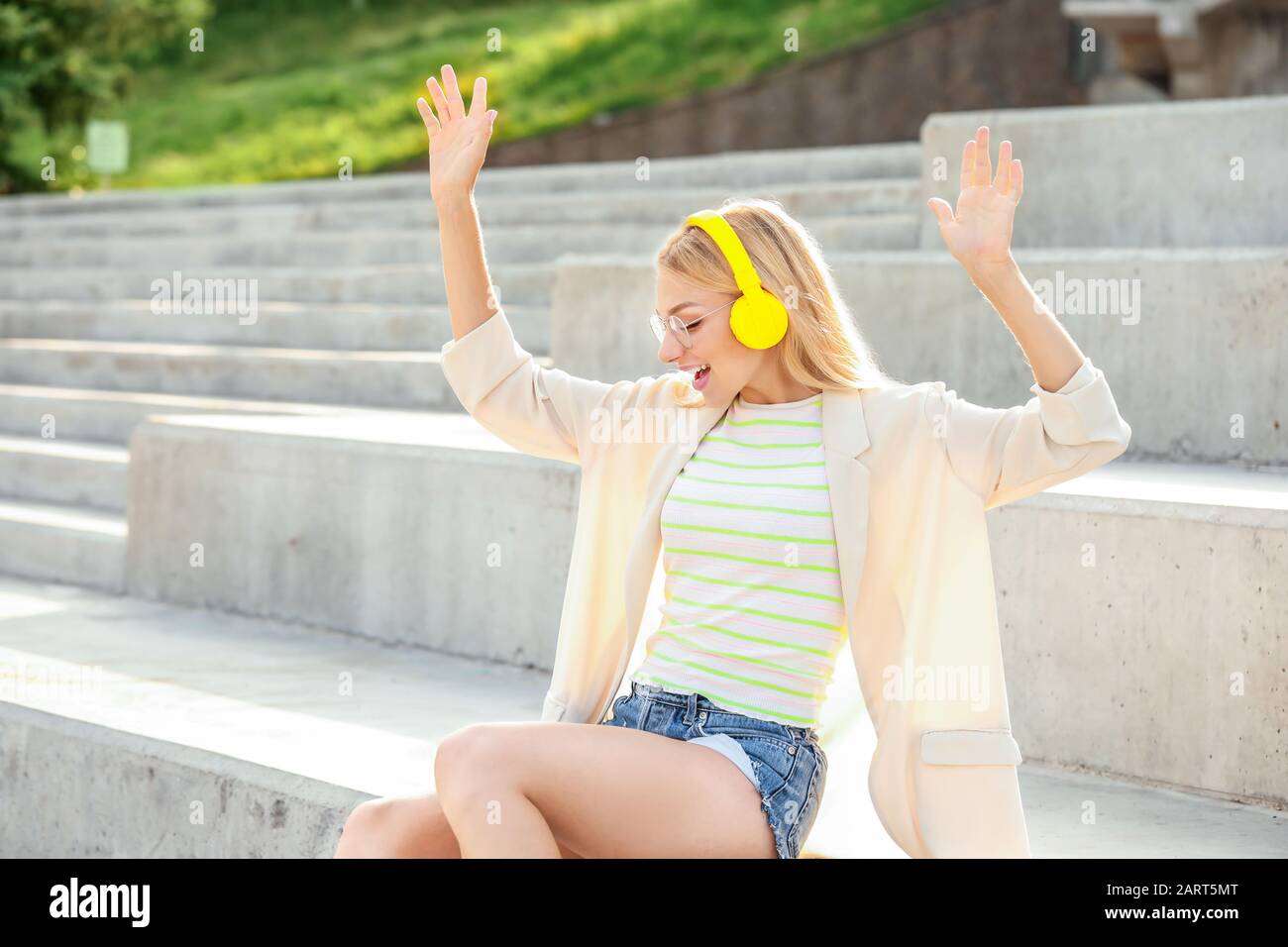 Beautiful young woman listening to music outdoors Stock Photo - Alamy