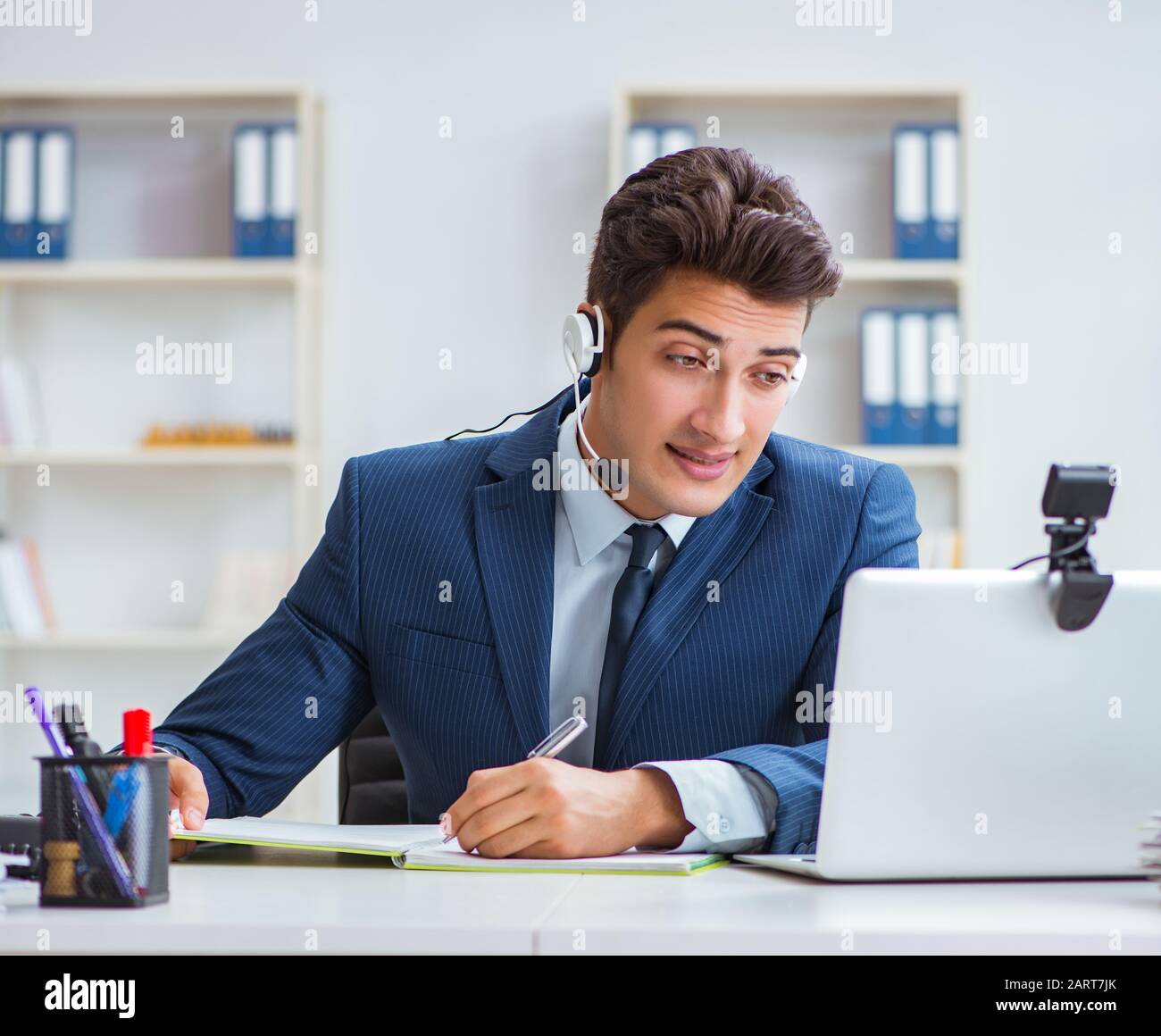 The Young Help Desk Operator Working In Office Stock Photo