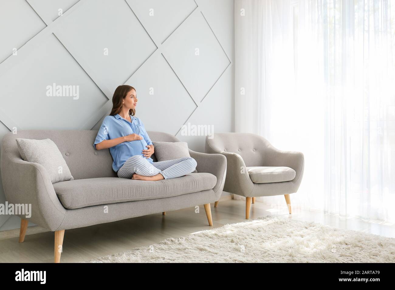 Beautiful pregnant woman sitting on sofa at home Stock Photo Alamy