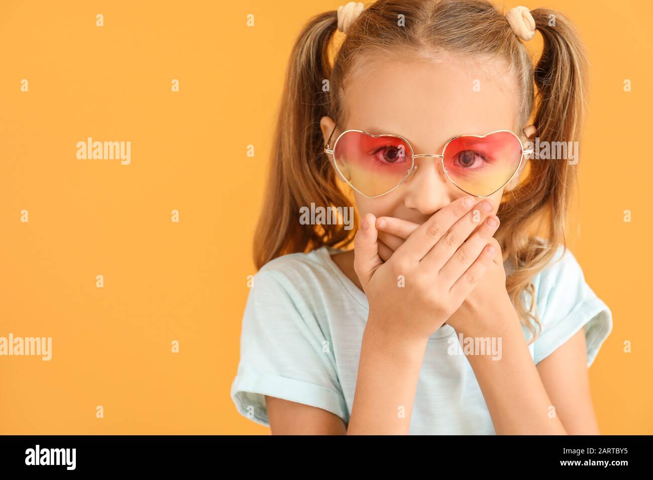 Surprised little girl on color background Stock Photo - Alamy