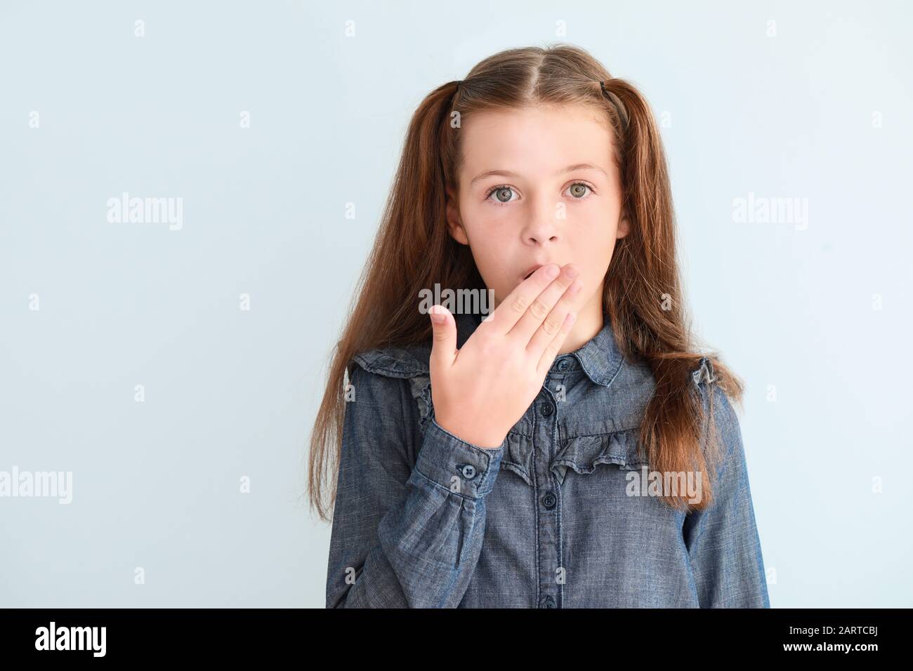 Surprised little girl on light background Stock Photo - Alamy