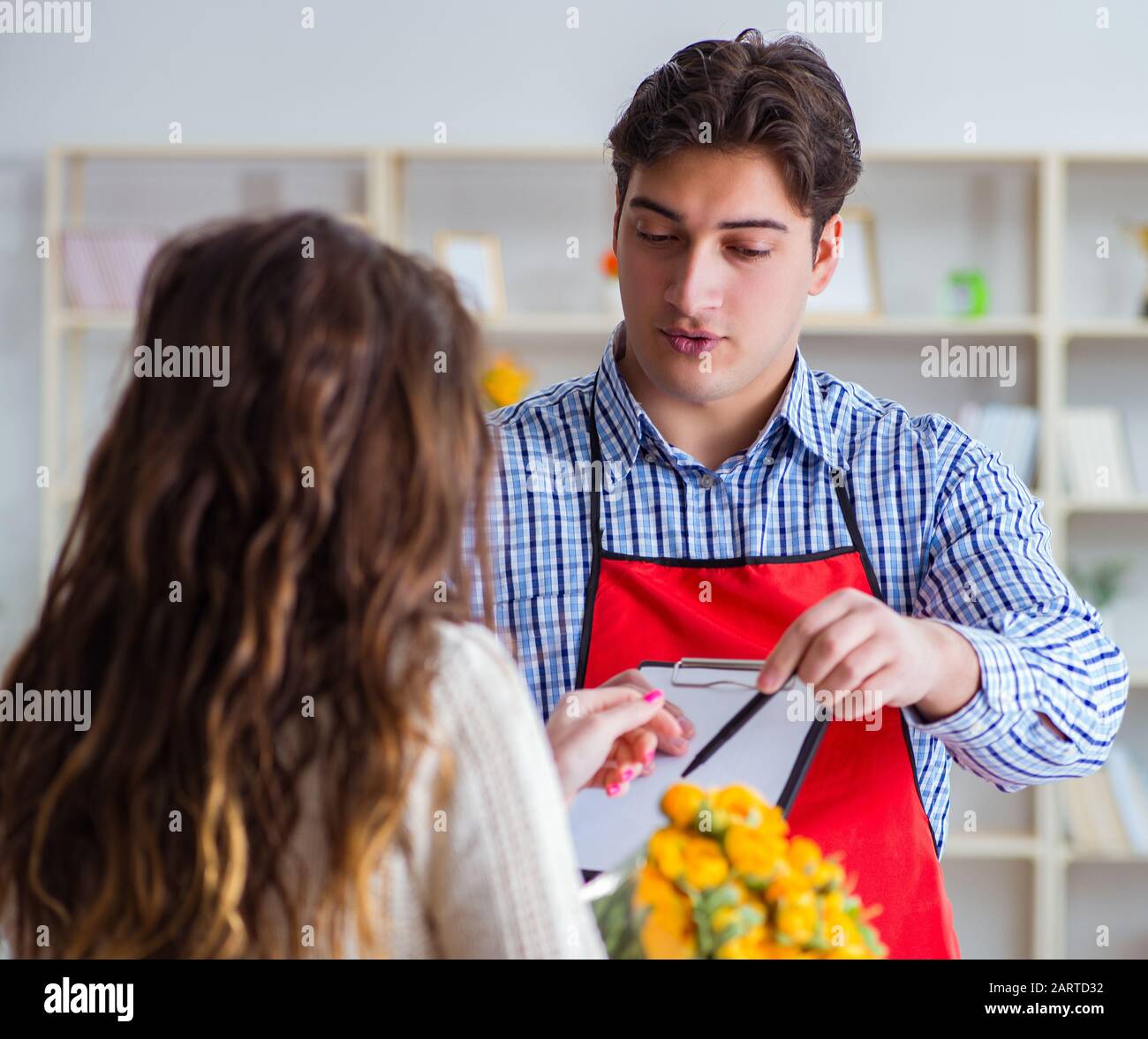 Flower shop assistant selling flowers to female customer Stock Photo