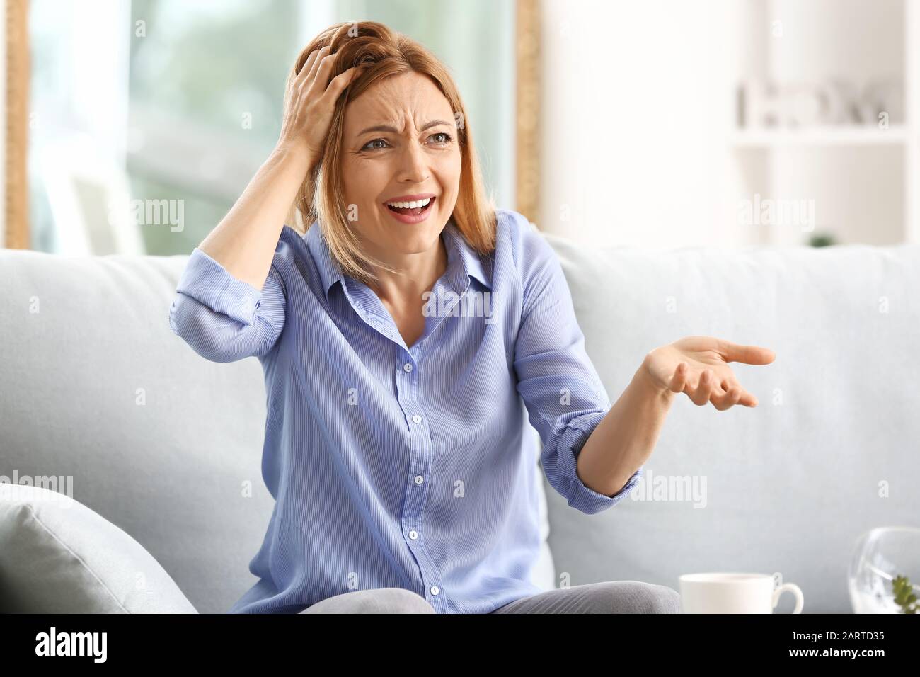 Stressed woman sitting on sofa at home Stock Photo - Alamy