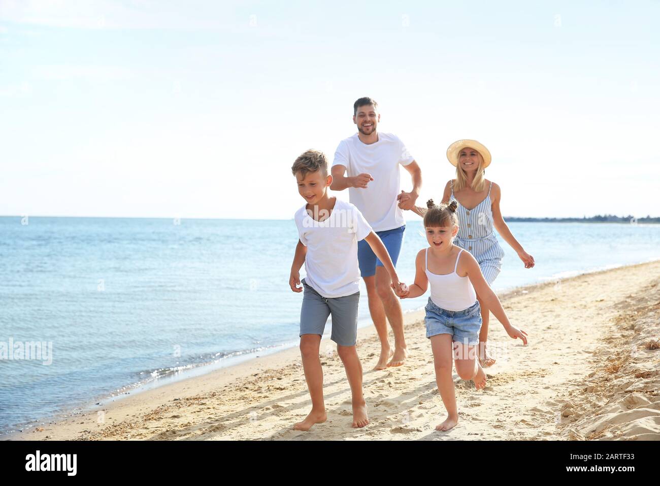 Happy family running on the beach hi-res stock photography and images ...