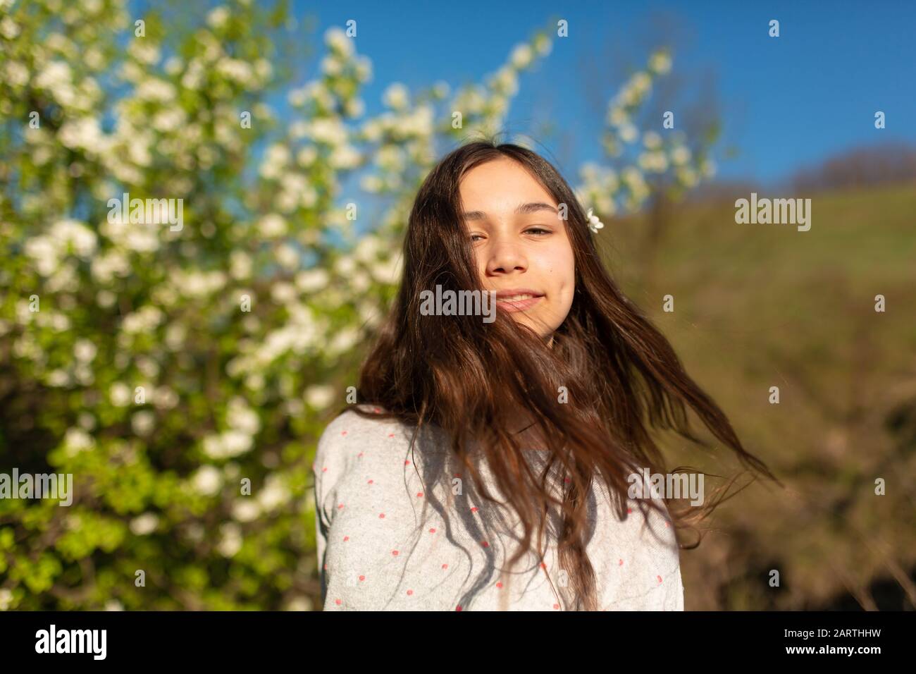 Portrait of a young beautiful teenager girl in a blooming spring green ...