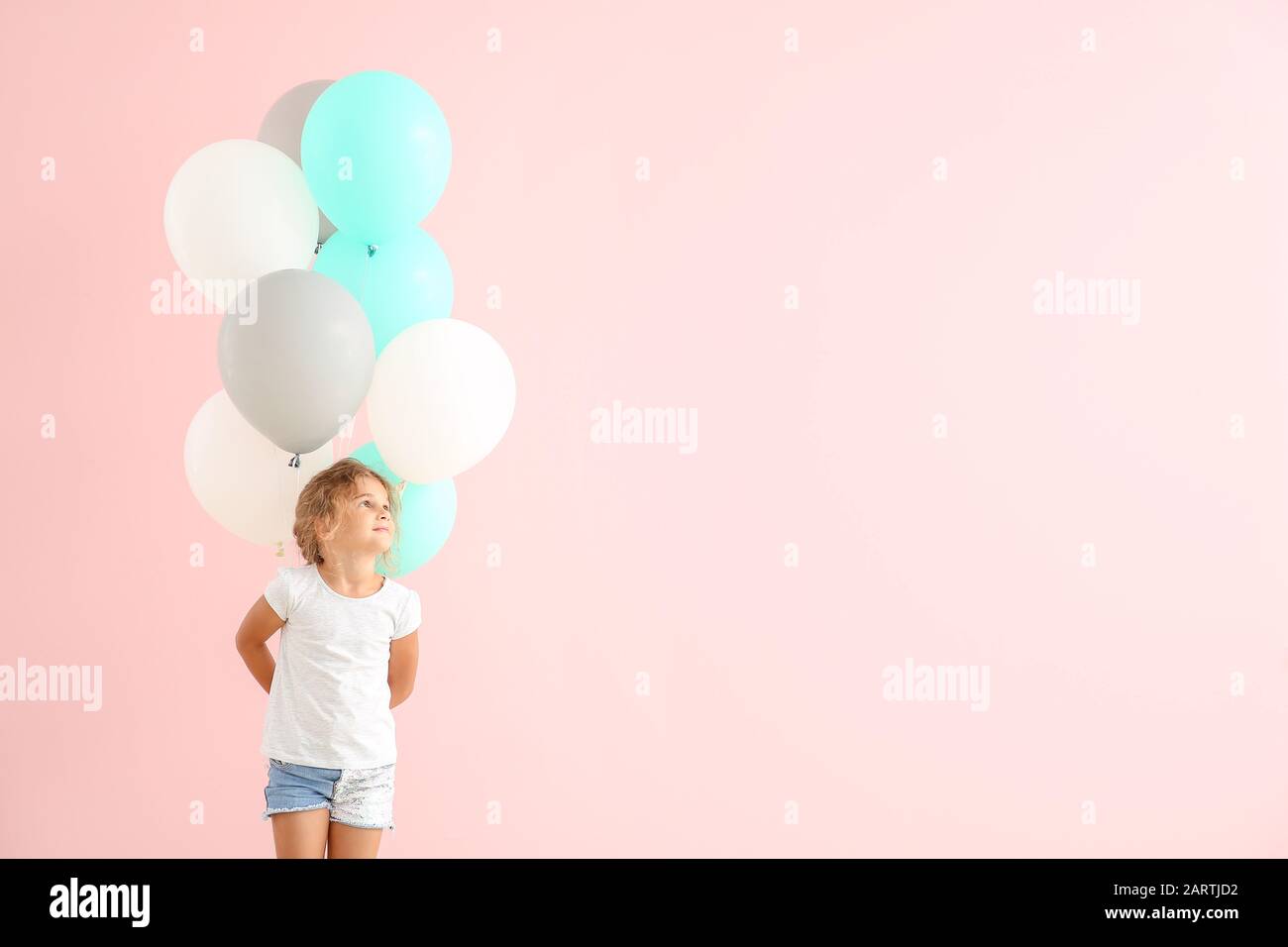 Little girl with balloons on color background Stock Photo - Alamy