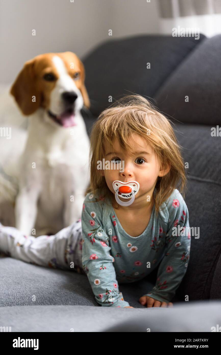 Cute 2 year old Baby girl on a bed on her belly with head up looking
