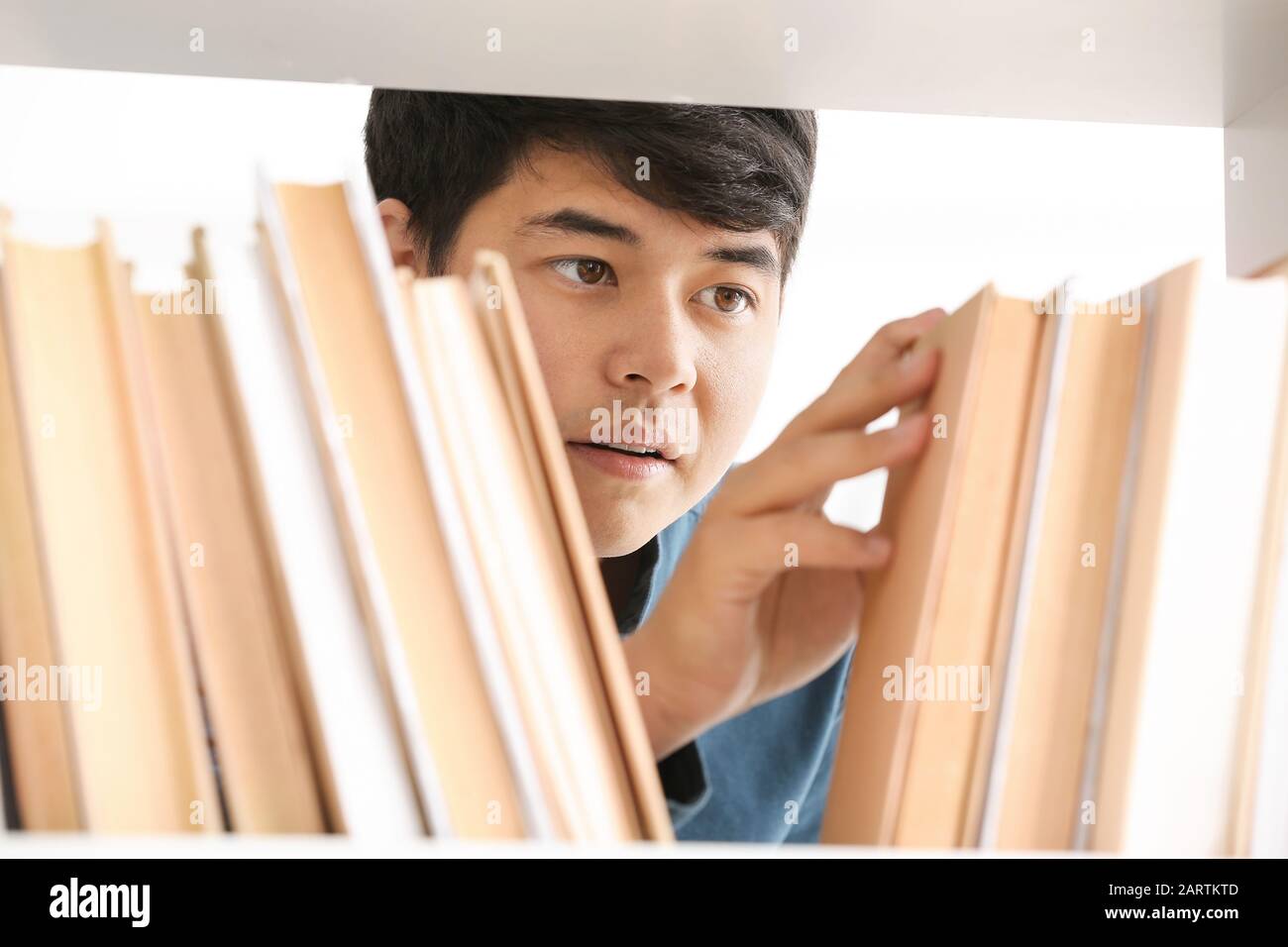 Asian student choosing book in library Stock Photo