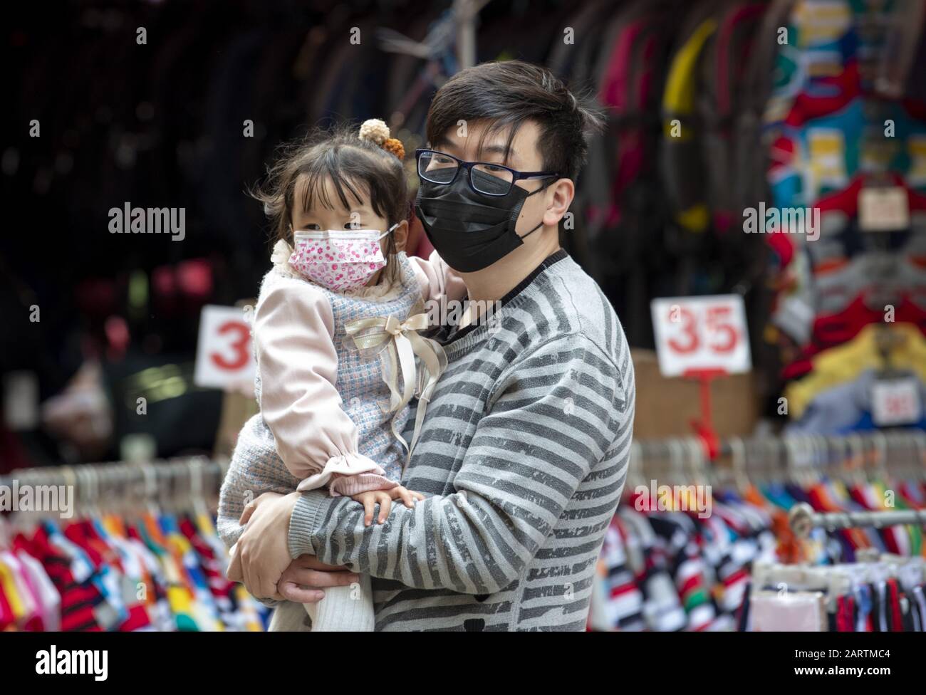 January 29, 2020, Hong Kong, Hong Kong SAR, China: A father and child wear masks. Fear of the Coronavirus from Wuhan China is evident on the streets of Hong Kong. North point markets are still busy. A father and daughter wear surgical masks (Credit Image: © Jayne Russell/ZUMA Wire) Stock Photo