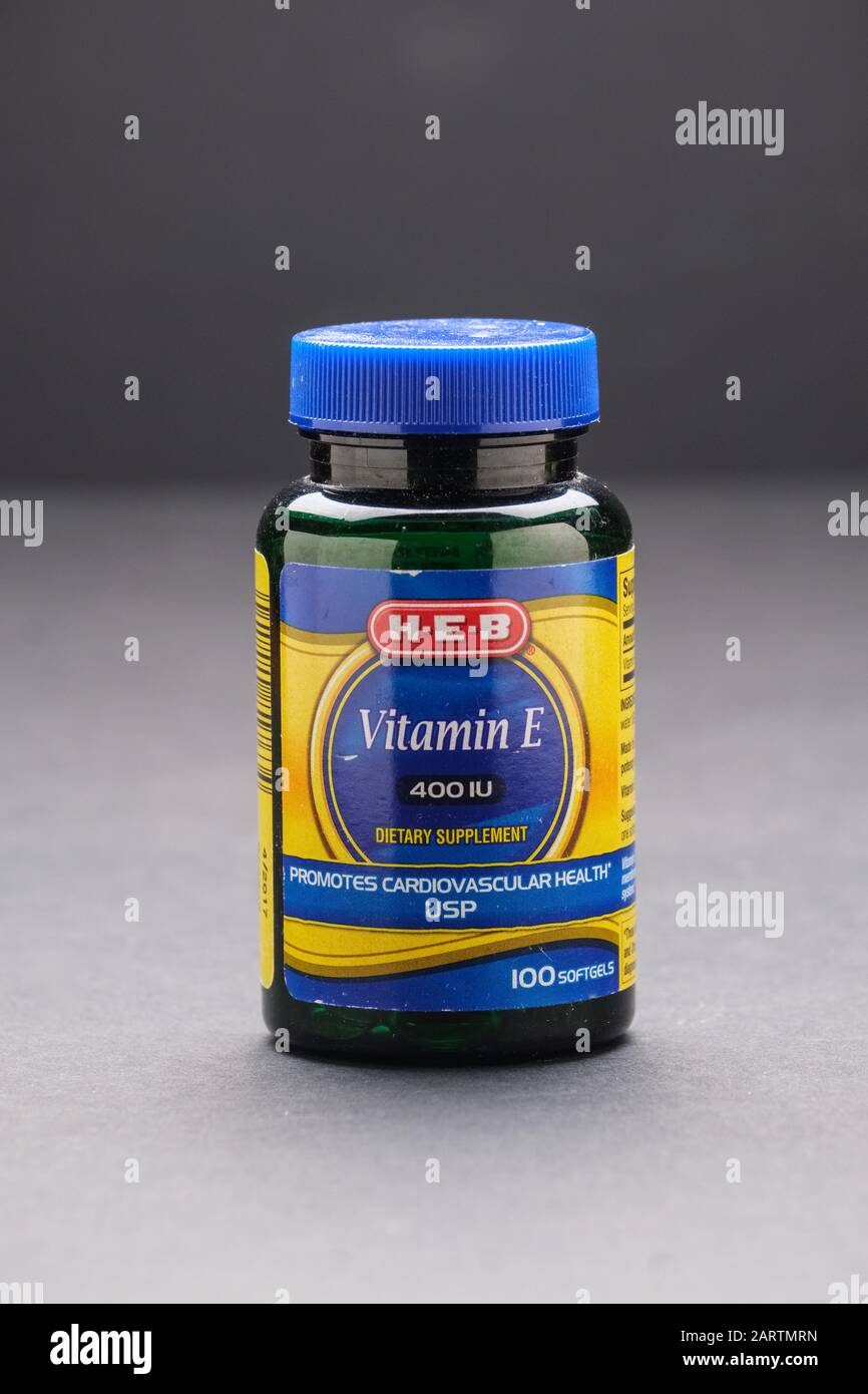 Plastic bottle of vitamin E dietary supplement on dark background Stock Photo