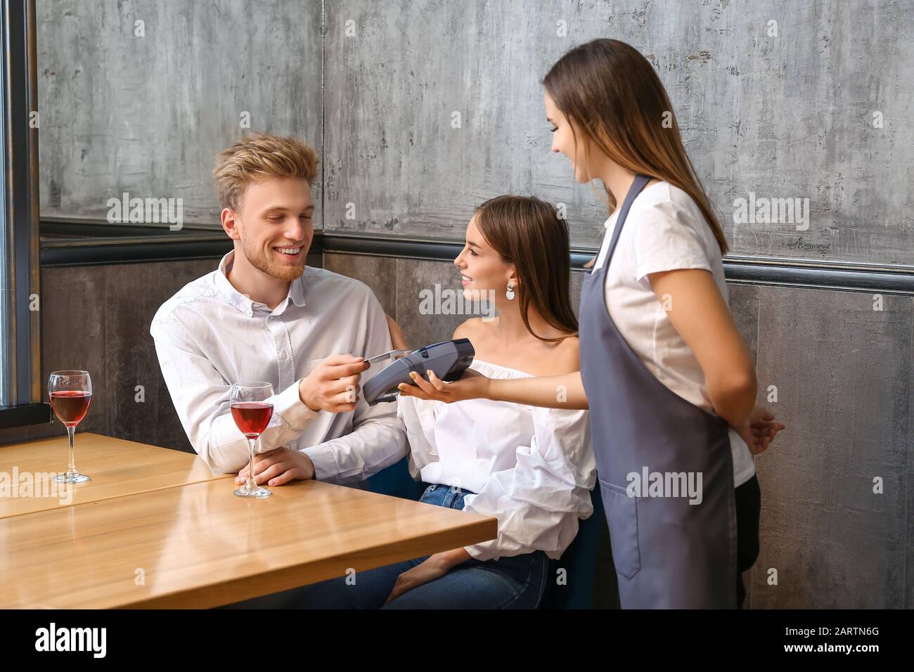 Man paying bill in restaurant through terminal Stock Photo