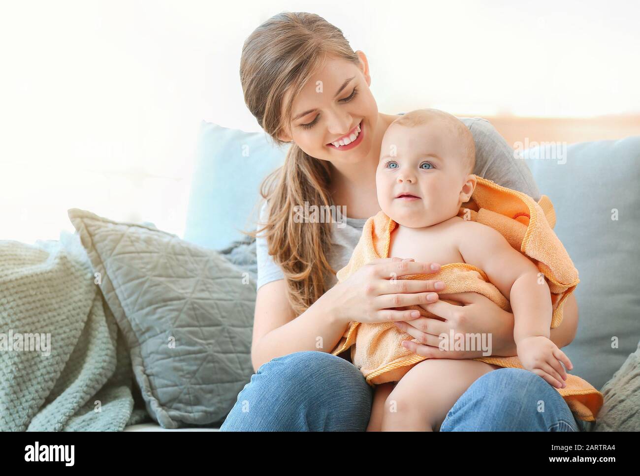 Mother wiping her cute little baby after bathing at home Stock Photo