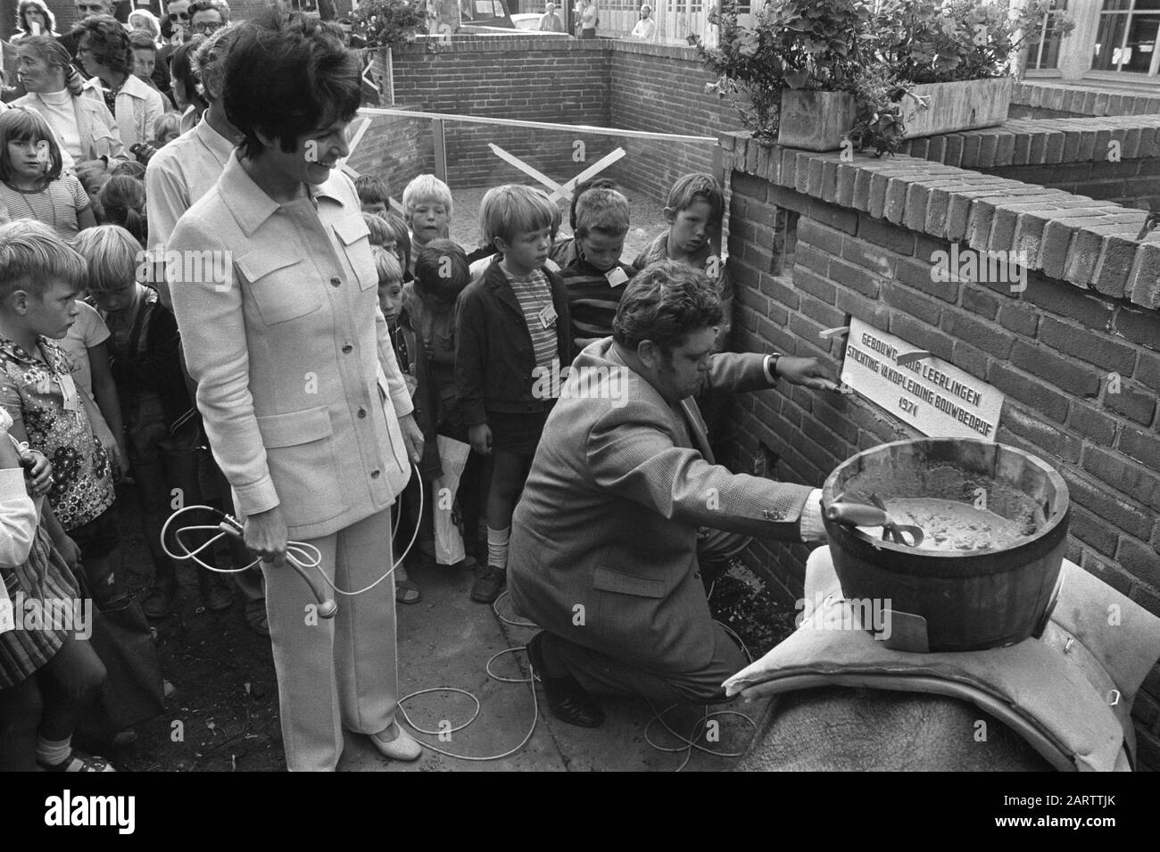 State Secretary Vonhoff mast stone in apprenticeship building site Artis in connection with 25 years Foundation Vakopleiding Bouwnijverheid Amsterdam, Standing Mies Bouwman Date: 9 September 1971 Location: Amsterdam, Noord-Holland Keywords: zoos, state secretaries, stones Personname: Bouwman, Mies, Vonhoff, Henk Stock Photo