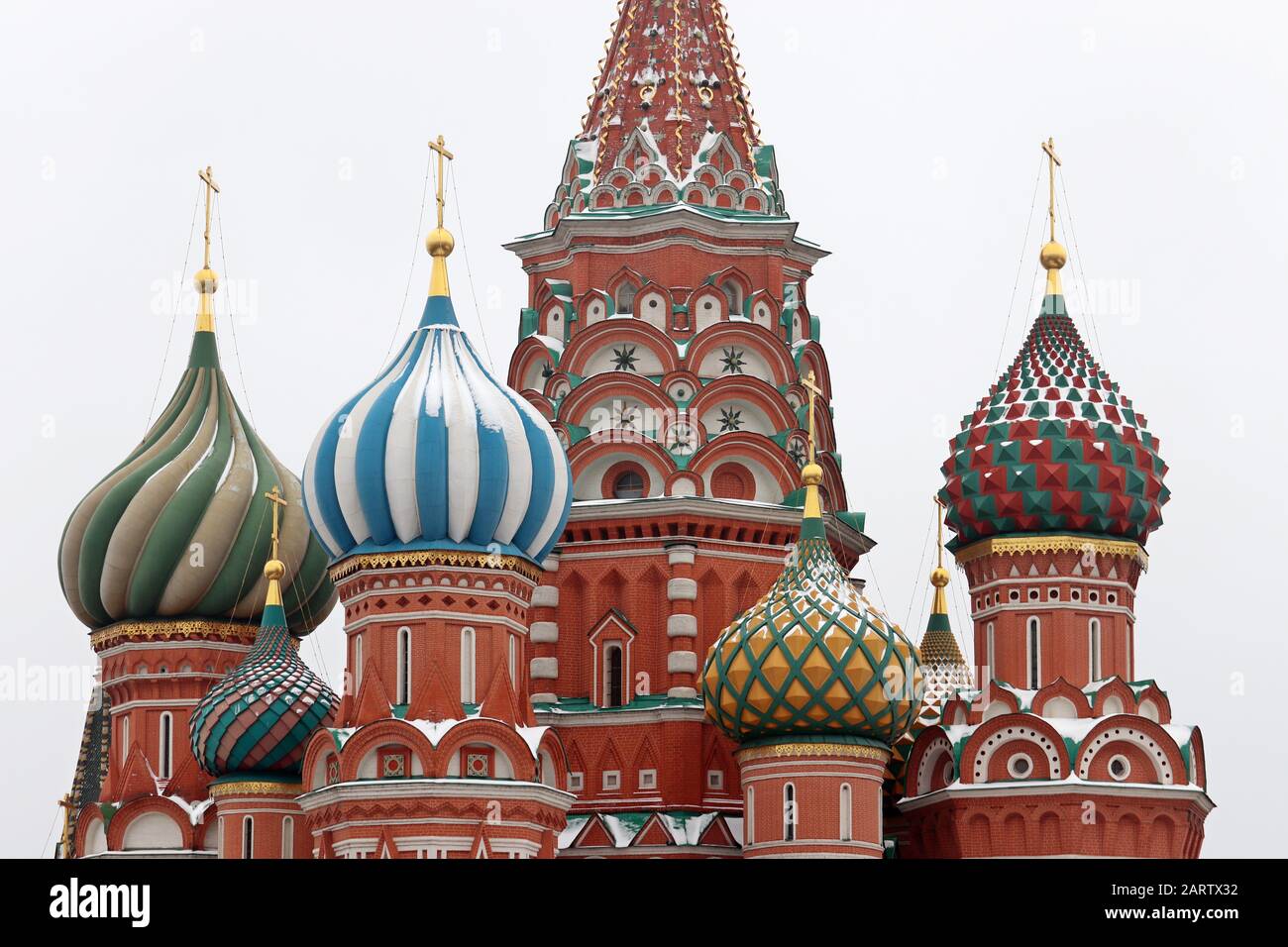 St. Basil's Cathedral against the winter sky, close-up of domes covered with snow. Russian architecture landmark, located on Red square in Moscow Stock Photo