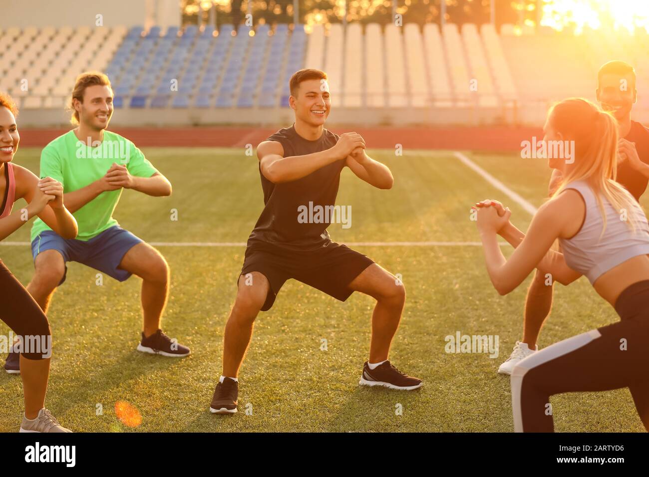 Group of sporty young people training at the stadium Stock Photo - Alamy