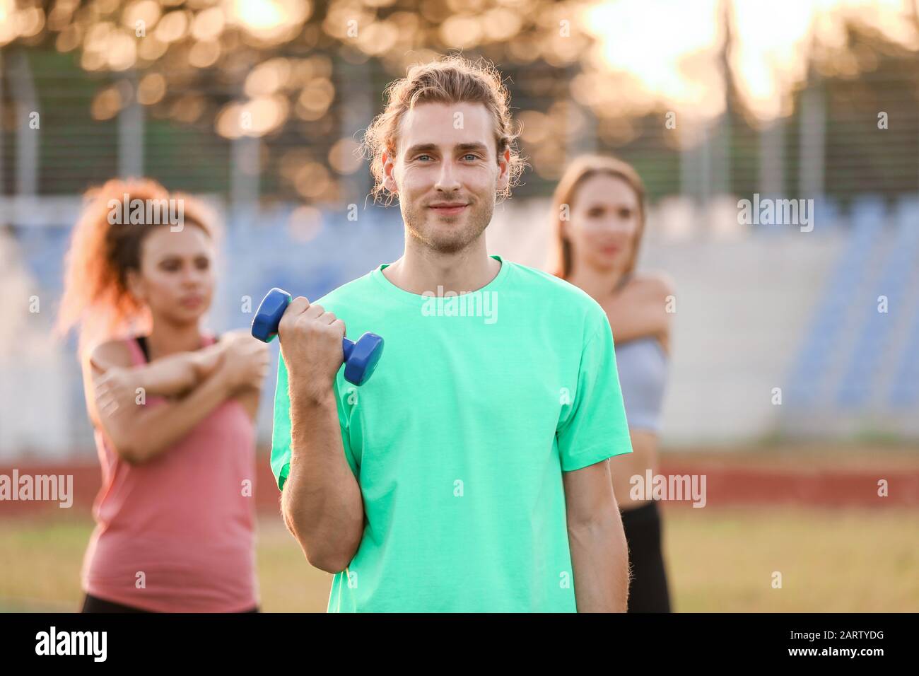 Group of sporty young people training at the stadium Stock Photo - Alamy