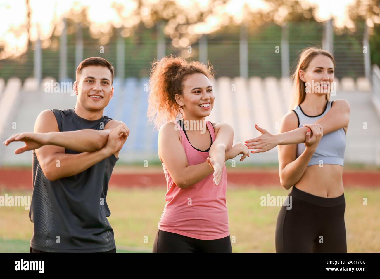 Group of sporty young people training at the stadium Stock Photo - Alamy
