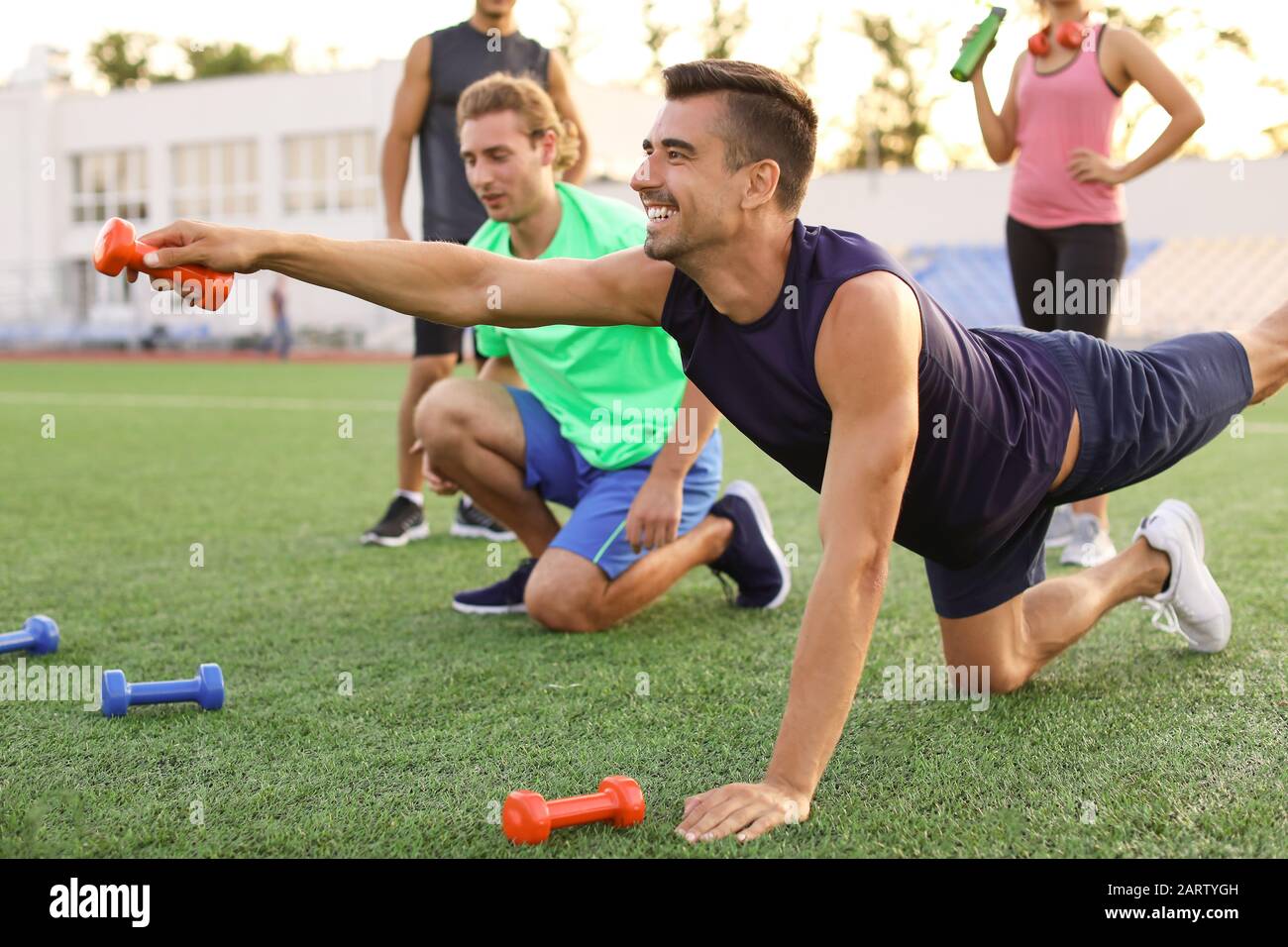 Group of sporty young people training at the stadium Stock Photo - Alamy