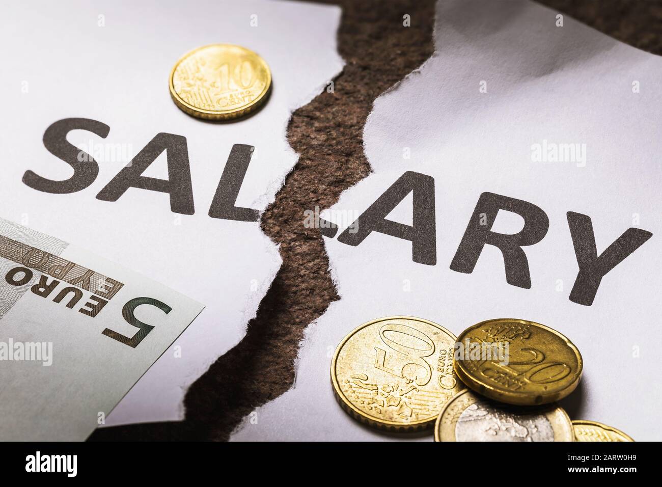 The paper with the inscription Salary is torn in half, next to it are EU money. Unpaid salary concept Stock Photo