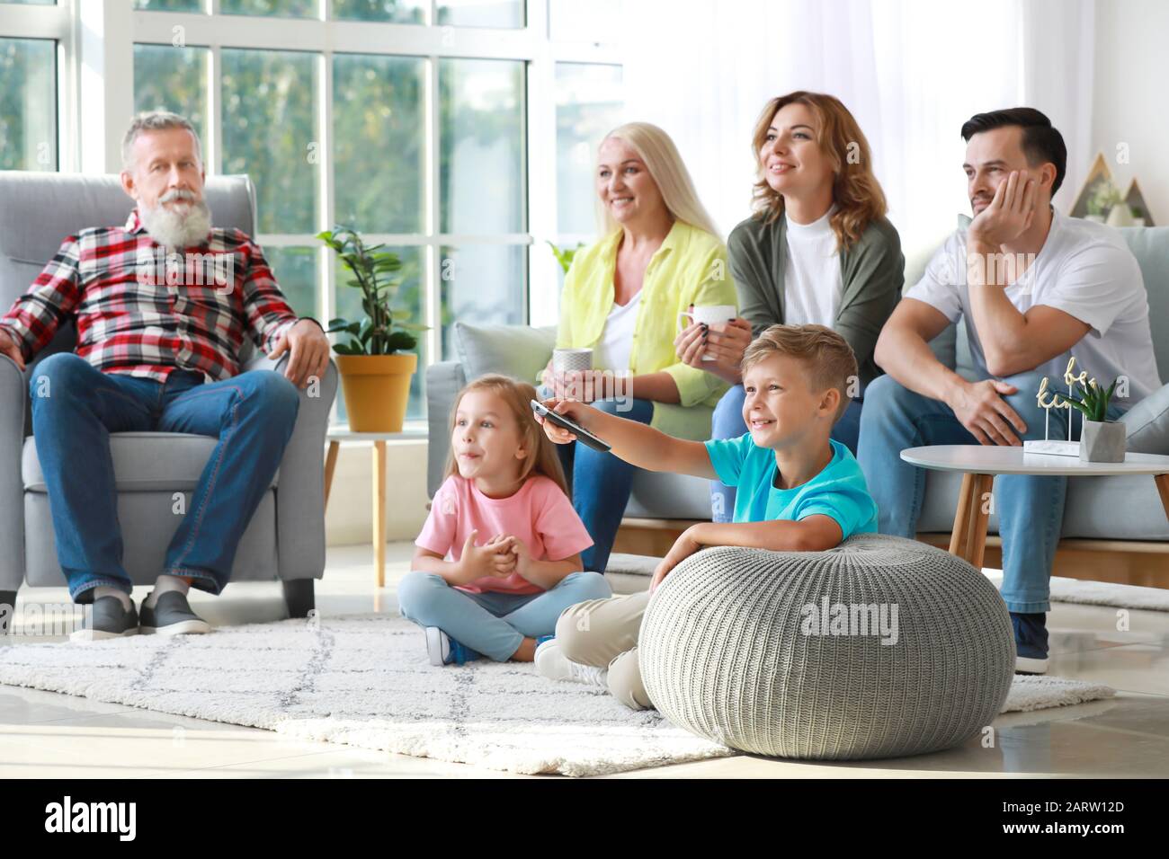 Big family watching TV together at home Stock Photo - Alamy