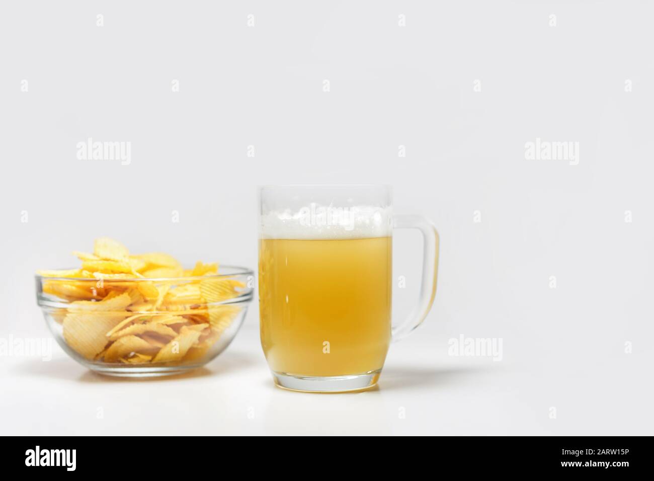 bowl of potato chips or crisps and a glass of wheat beer Stock Photo