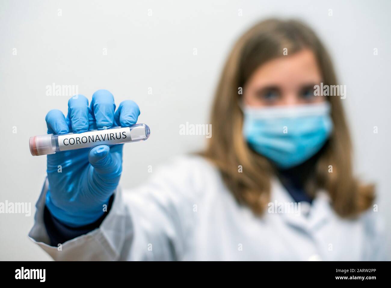 Doctor holds a test vessel with a sample of the coronavirus Stock Photo