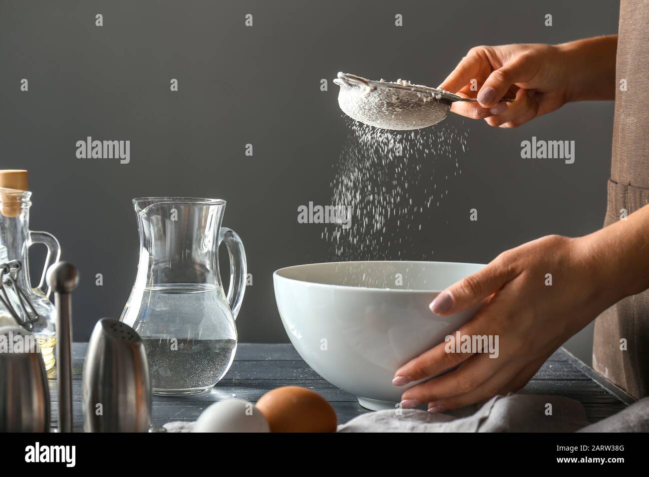 Woman sieving flour in kitchen Stock Photo Alamy