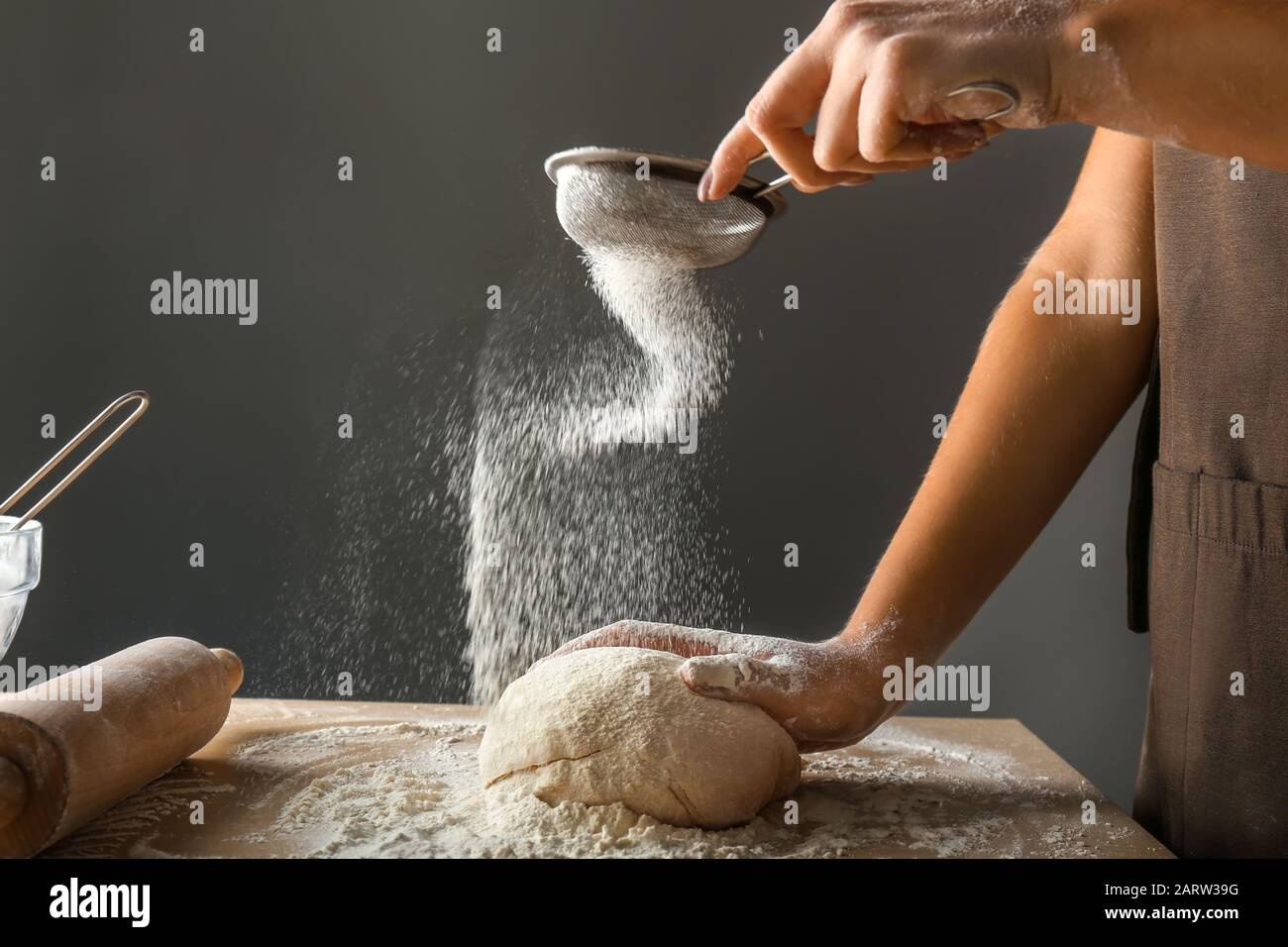 Woman sieving flour in kitchen Stock Photo Alamy