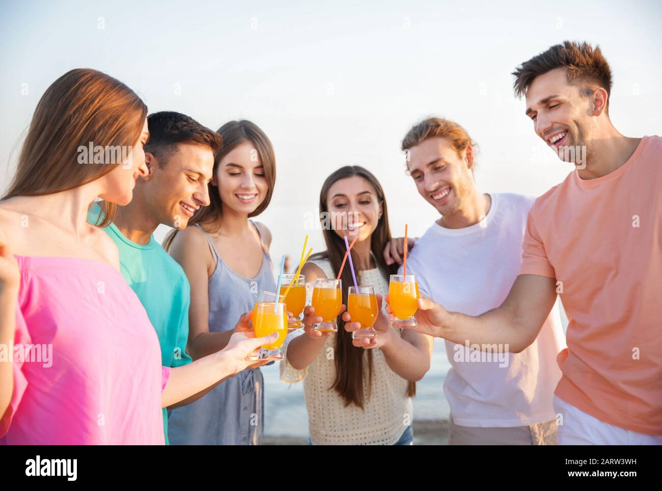 Friends drinking juice on sea beach Stock Photo Alamy
