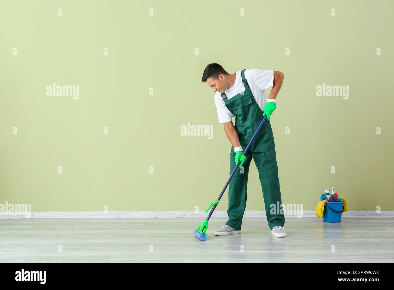 Young man mopping floor in room Stock Photo