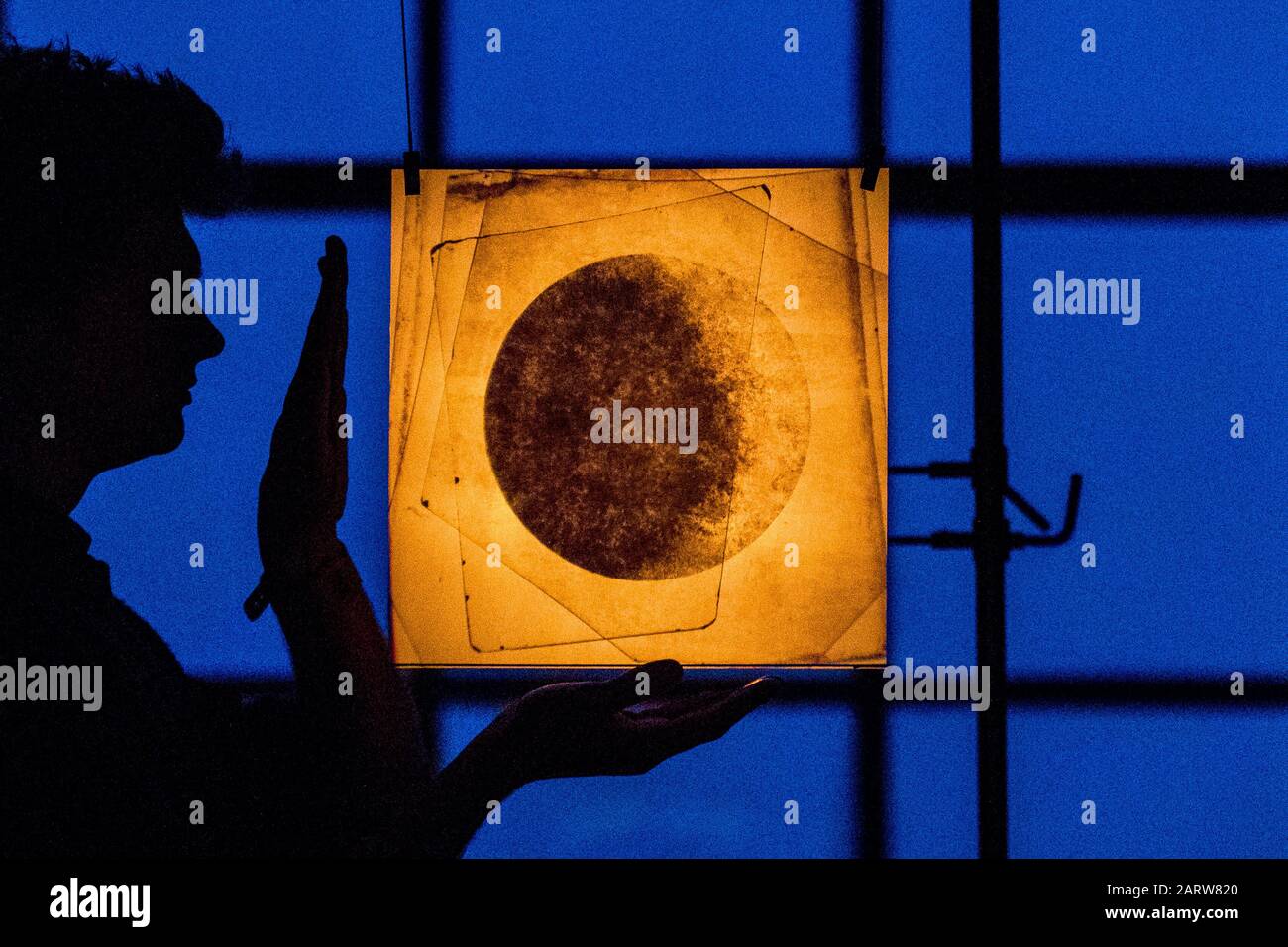 Artist James Russell of JAMESPLUMB stands beside an optical instrument