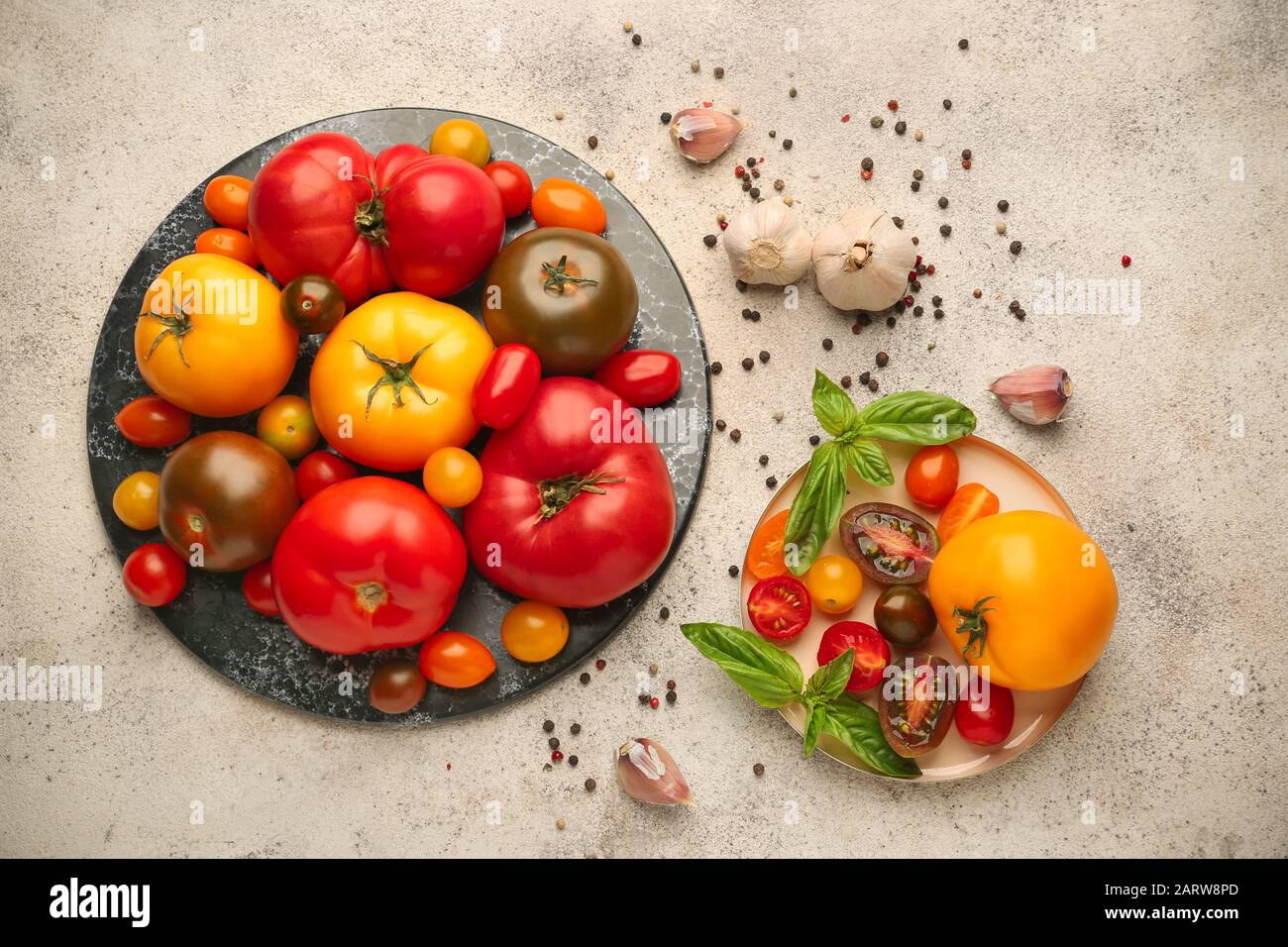 Different fresh tomatoes and spices on light background Stock Photo