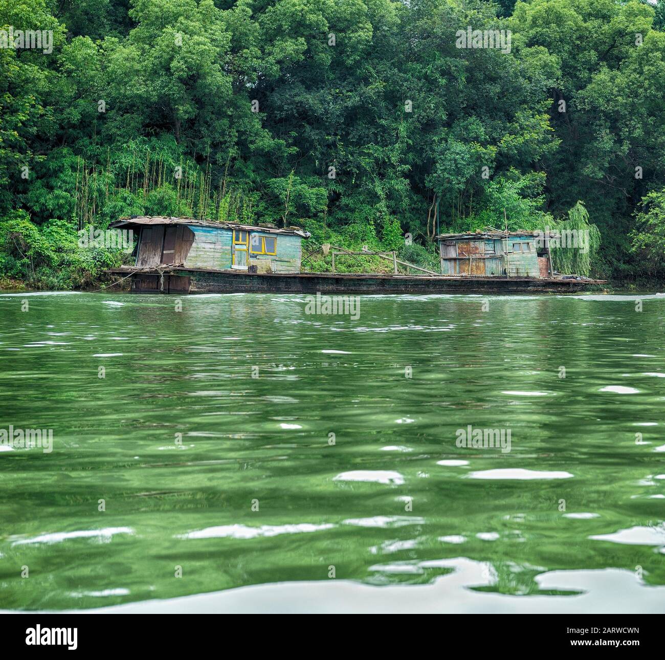 Picturesque ancient wooden barge, full of colors, at spectacular Li river known for famous Karst mountains. Stock Photo