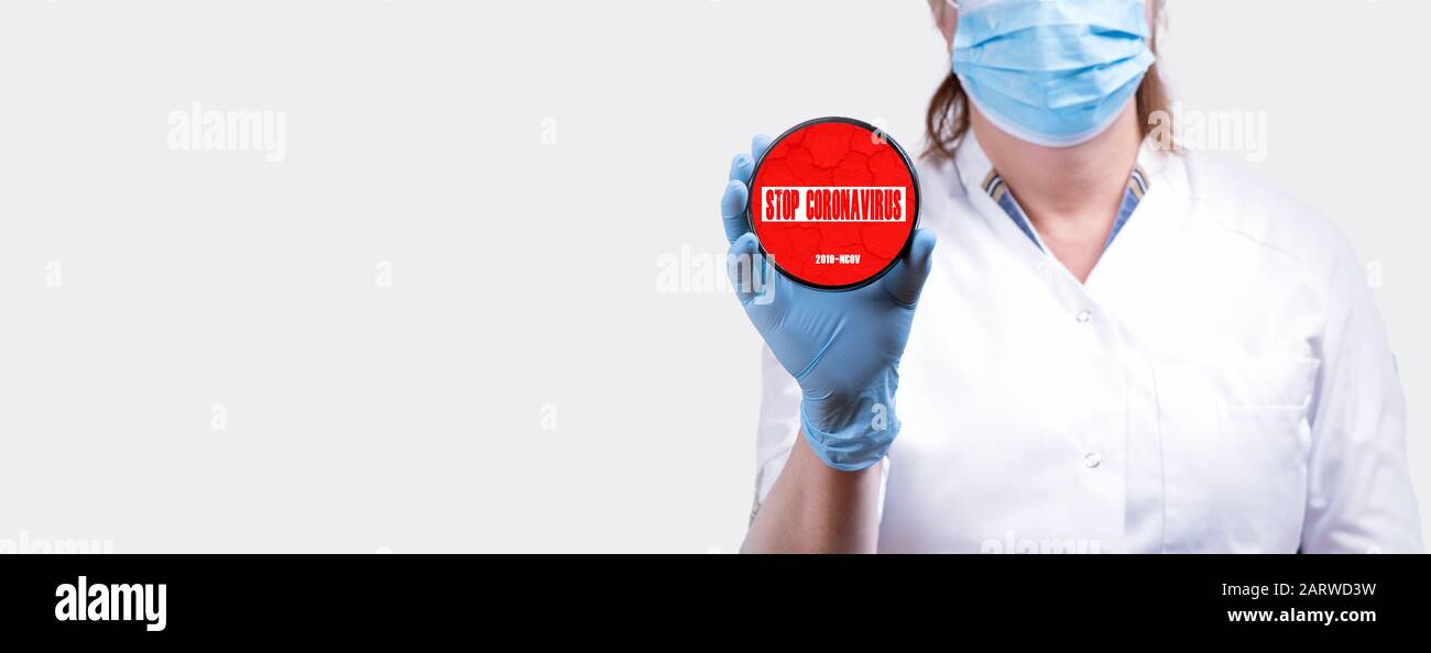Female doctor hand holding sign with text stop coronavirus 2019 ncov virus infection prevention concept banner. Stock Photo